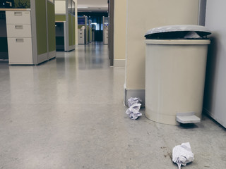 Crumpled paper was left beside the trash.