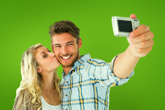 Attractive couple taking a selfie together against green vignette