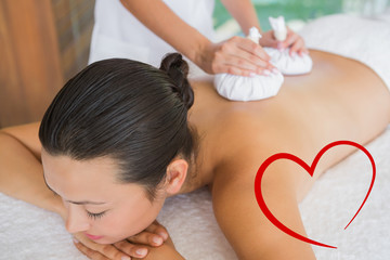Obraz na płótnie Canvas Content brunette getting a herbal compress massage against heart