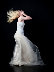 Naklejka premium full length portrait of woman wearing white bridal gown. standing poison black studio background.