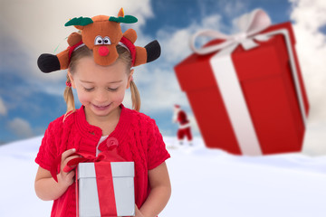 Cute little girl wearing rudolph headband against blue sky with white clouds