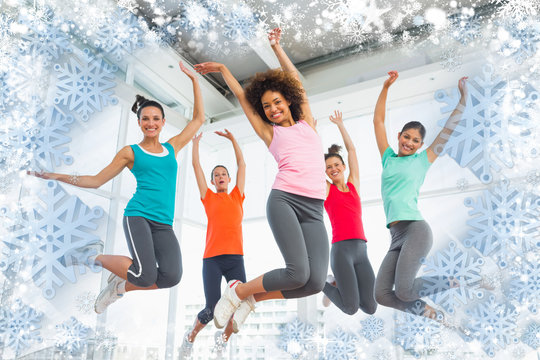Composite image of snow frame against fitness class and instructor jumping in fitness studio