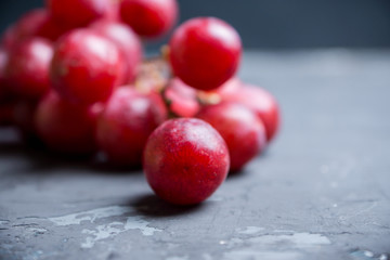Sweet bunch of red grapes on th rustic background. Selective focus. Shallow depth of field.