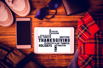 Thanksgiving words against shirt shoes jean glasses next to wallet smartphone and bag 