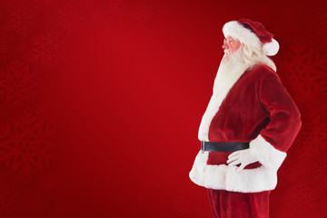 Santa Claus shows his side to camera against red background