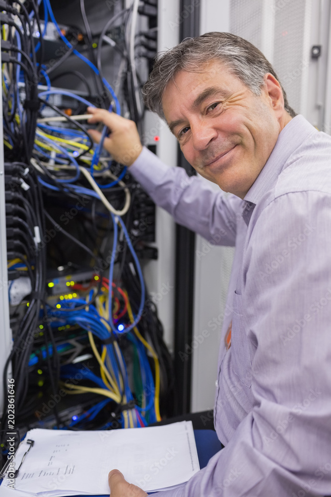 Poster smiling technician checking the server