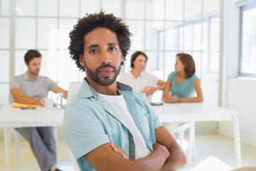 Portrait of a serious businessman with colleagues in meeting