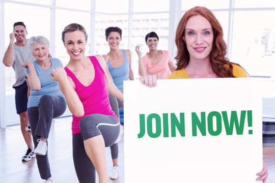 Pretty redhead showing a card against join now - Powered by Adobe