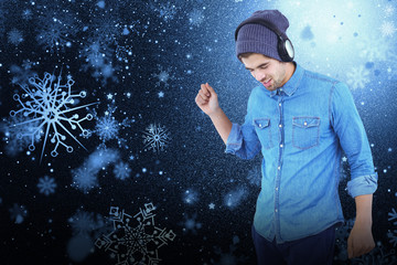 Hipster wearing headphones enjoying music against snowflake pattern