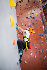 Determined boy practicing rock climbing