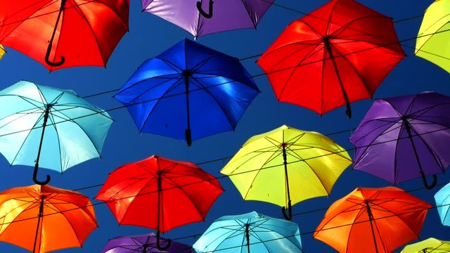 colored umbrellas. vivid colorful umbrellas sweep overhead against the blue sky