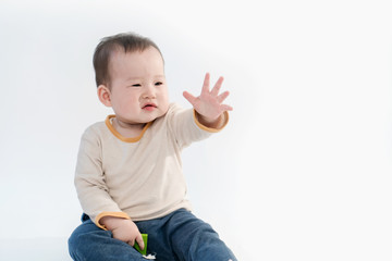 The baby is playing on the floor, the white background