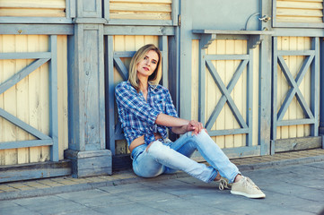 Stylish young woman in town . Girl dressed in jeans and a shirt . Casual wear