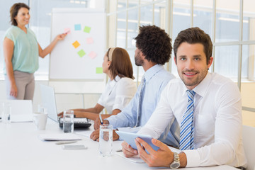 Young businessman with colleagues in boardroom meeting
