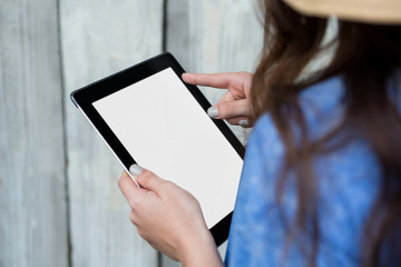 Woman in blue top using digital tablet