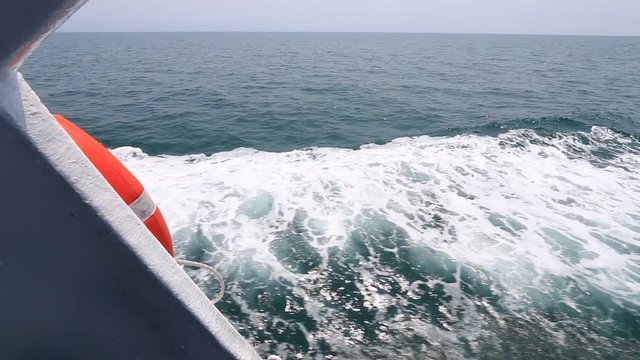 View from back and side view from boat with stainless steel barrier and rope for safe zone travel to the sea. Tail view of sailing Thailand ferry. Behind ship shot. full HD. 1920x1080P.