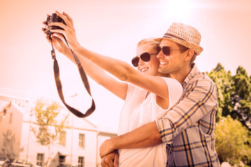 Stylish young couple taking a selfie on a sunny day in the city