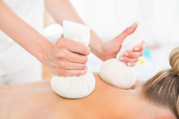 Fototapeta premium Beautiful blonde enjoying a herbal compress massage