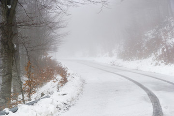Obraz na płótnie Canvas mountain road with fog and snow