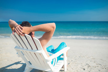 Man relaxing on deck chair at the beach