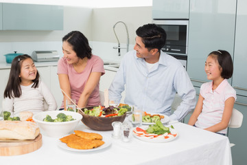 Obraz na płótnie Canvas Family of four enjoying healthy meal in kitchen