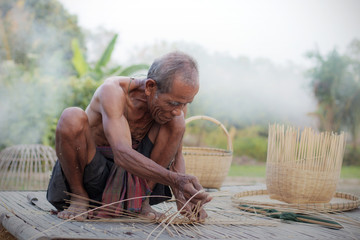 Old man are weaving in field.