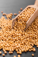 fresh grains of mustard on a rustic background