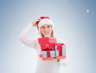 Confused blonde in santa hat holding gifts on vignette background