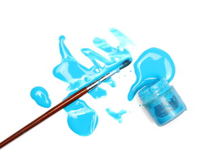 Spilled blue watercolor with paintbrush and bottle isolated on white background, top view