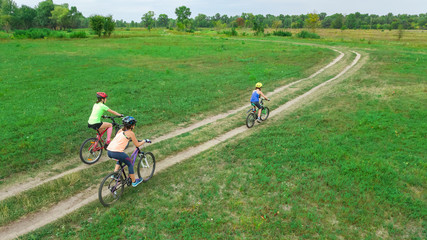 Obraz premium Family cycling on bikes outdoors aerial view from above, happy active mother with children have fun, family sport and fitness 