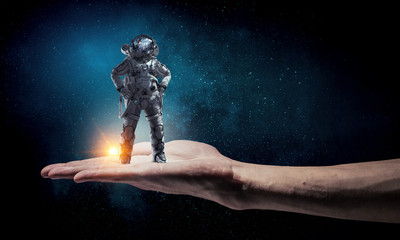 Naklejka premium Spaceman in male hand. Mixed media