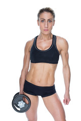 Female bodybuilder holding large black dumbbell with arm down looking at camera