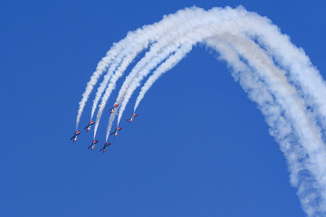 Sieben Flugzeuge einer Kunstflugstaffel fliegen einen Looping