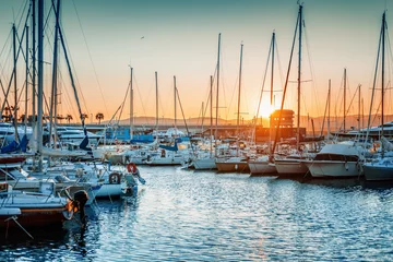 Fotobehang Seaport with boats and yachts on the Cote d'Azur in France at sunset, beautiful sea and city landscape © olezzo