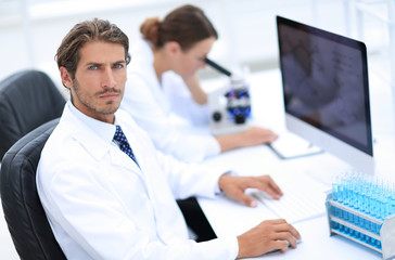 Young male technician working on computer in laboratory