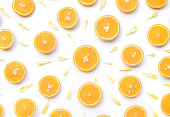 Top view of orange slice with flower petal on white background