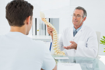 Doctor explaining spine to a patient in office