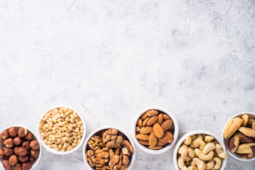 Nuts assortments on stone table top view.