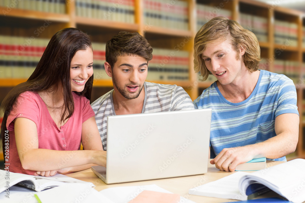 Poster college students using laptop in library against close up of a bookshelf