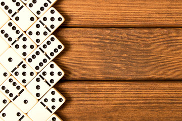 Domino game on wooden background . Top view . Empty space for text