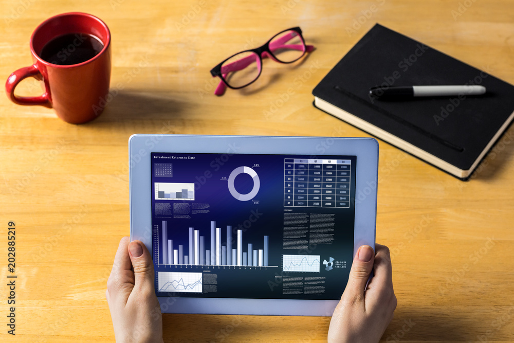 Aufkleber businesswoman using tablet at desk showing business interface with graphs and data