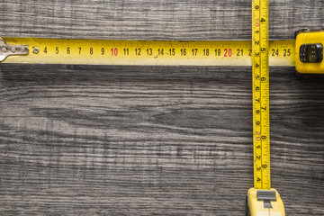 Old, yellow measuring tape on black wooden plank. Mock up for special offers as advertising or...