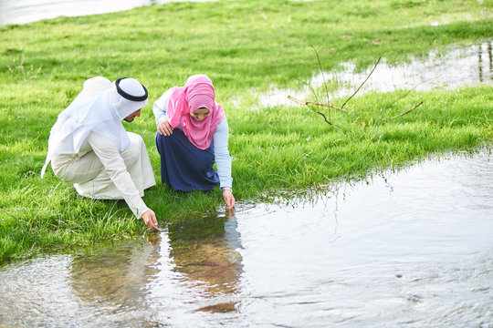 Muslim Couple Walking By The River