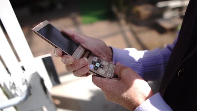 携帯電話を操作するシニアの手