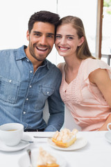Obraz na płótnie Canvas Portrait of a smiling couple at coffee shop