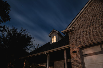 light in the window of a beautiful house under the night starry sky. Texas