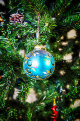 Blue ball decoration hangs on a Christmas tree.