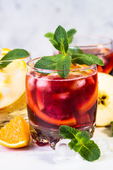 White, pink and red sangria with fruit, ice and mint.