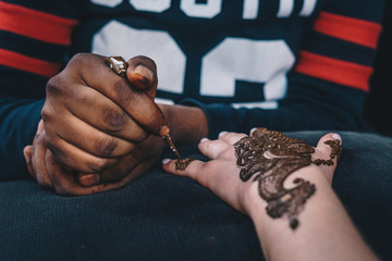 Weibliche Hand bekommt ein Henna Tattoo