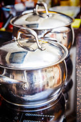 Shiny pans on the stove in the kitchen